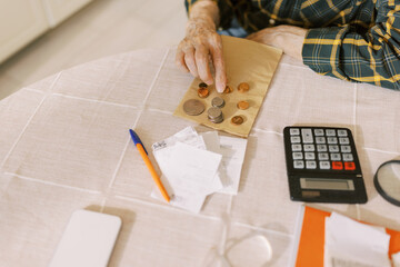 Senior man counting the money and making calculation 
