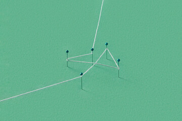 Several stationery pins stuck in green paper and tied with thread