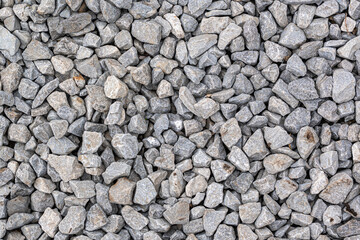 A detailed texture of gray gravel evenly sprinkled with brown iron oxide spots fills the entire frame, offering a natural, earthy pattern.