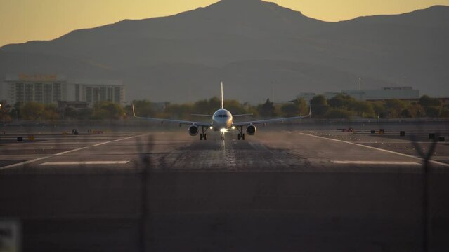 Airplane is speeding up and taking off from Harry Reid International Airport in Las Vegas at evening during sunset in beautiful place in Nevada