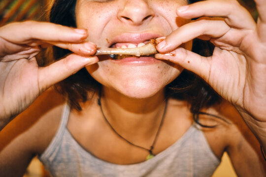 woman eating a bbq wing with her hands