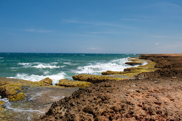 un lugar al norte de la guajira colombiana, llamado playa arco iris, donde la olas golpean con...