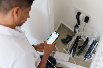 Focused man using smartphone during technical work
