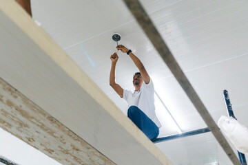 Focused male worker installing security camera