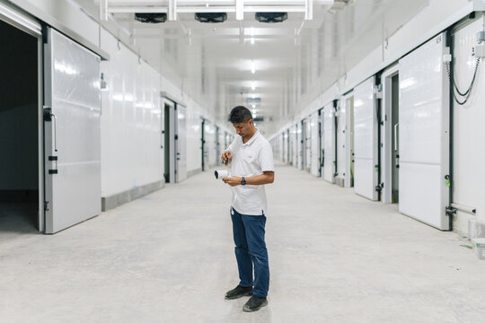 Focused employee installing CCTV camera in warehouse