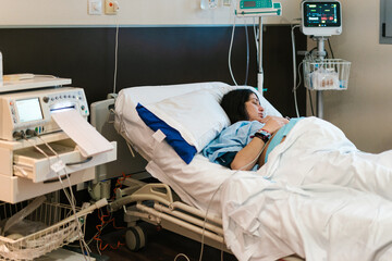 Pregnant female patient lying on medical bed in hospital