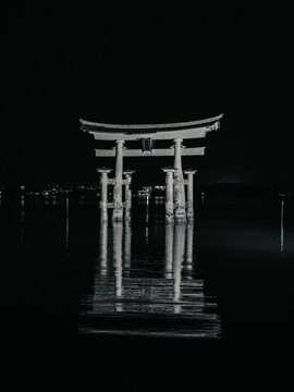Ancient japanese large torii gate in the middle of the sea at night