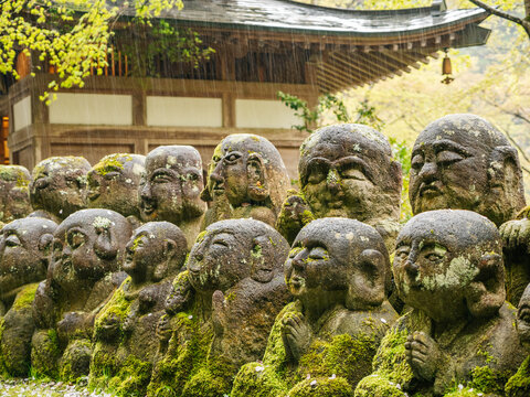 Carved stone statues of rakan at ancient Japanese Buddhist temple