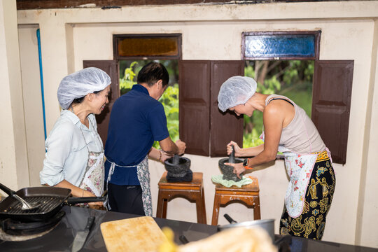 People grinding spices in cooking class.