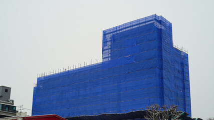 Scenery of buildings under construction covered with a blue curtain