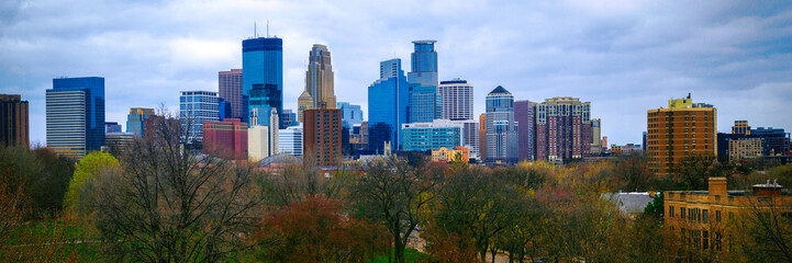 Minneapolis City skyline, skyscrapers, and diverse architecture over the forest park in Minnesota, USA, a vibrant hilltop panoramic view on a stormy springtime