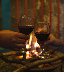 copas de vino brindando con una fogata de fondo en un ambiente romantico