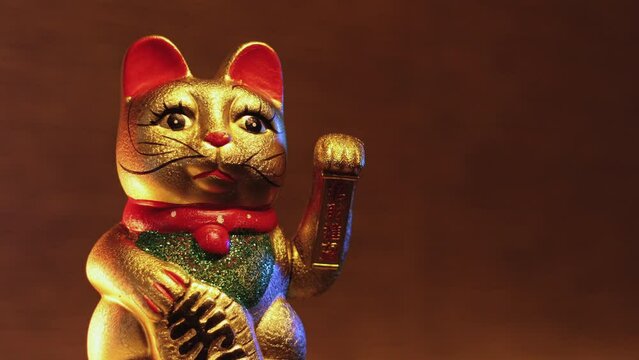 Detail video of Japanese Waving Cat statuette called Maneki-Neko which is said to bring luck and wealth to a business.