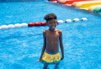 Portrait of a cute African American boy smiled happily after slipping down a steep slider.