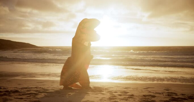 Dinosaur costume, funny and kickboxing at beach with fun, and performance and fight in air. Fitness, sunset and inflatable mascot with punch for energy, entertainment and cardio exercise in nature