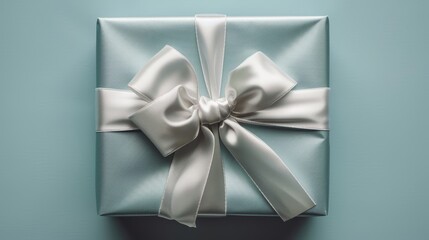 Elegant Christmas present in a top view close-up, pristine white wrapping with silver ribbon, set against a pale blue backdrop, studio illumination