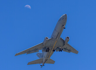 A military refueling tanker with the moon as a backdrop