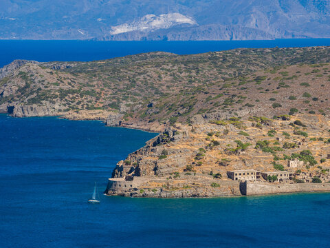 Spinalonga island with a yacht and peninsula behind (Plaka, Crete, Greece)