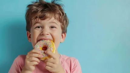 Foto op Plexiglas The boy is eating a donut. © Sittipol 