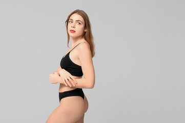 Fototapeta premium Sexy young woman in black cotton underwear on light background