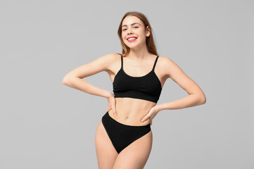 Beautiful young woman in black cotton underwear on light background - obrazy, fototapety, plakaty