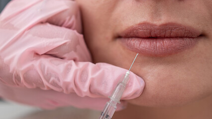Close up of Beautiful woman Mouth and Lips: Female Doctor Injecting Botox for Lip Rejuvenation...