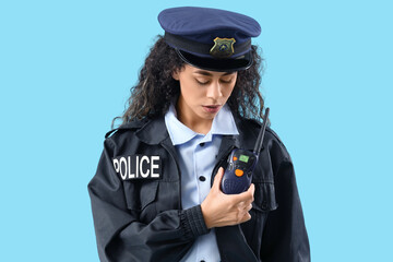 African-American female police officer with radio transmitter on blue background