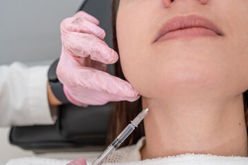close up of Botox injection for chin beauty treatment in young unrecognizable woman by doctor: dermatology procedure