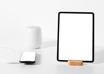 Tablet and phone png screen mockup next to voice assistant smart home technology