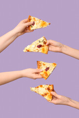 Many hands holding tasty pizza slices on lilac background