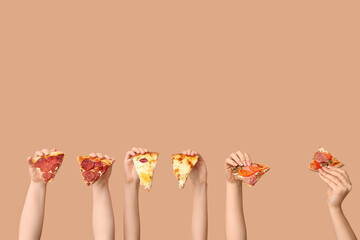 Many hands holding pizza slices on beige background