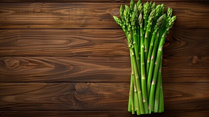   A selection of green asparagus arranged on a wooden table, nearby lies a piece of broccoli