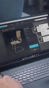 Small business owner uploads pictures of stylish wooden chair to online store website using laptop. Craftsman adds photos of his product to the internet marketplace for sale. Vertical shot