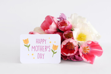 Greeting card with text HAPPY MOTHER'S DAY and beautiful tulips on white background