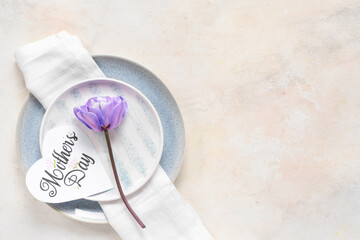 Table setting with greeting card for Mother's day and flowers on white background