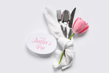 Table setting with greeting card for Mother's day and tulip isolated on white background