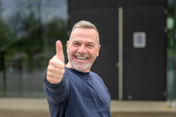 Enthusiastic motivated attractive middle aged man giving a thumbs up gesture