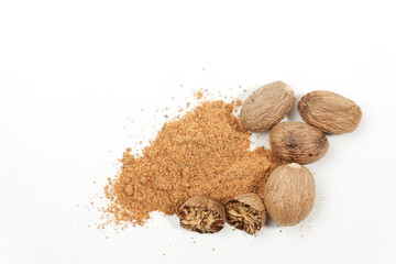 whole nutmeg, halved and ground, on a wooden spoon isolated on a white background and copy space