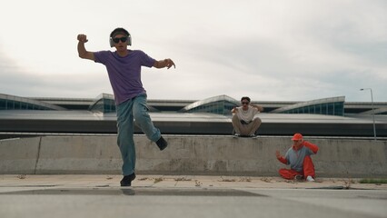 Group of skilled break dancer perform street dance with friend looking and cheering at him....