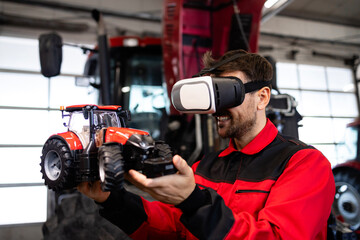 Serviceman using virtual reality glasses and tractor model in workshop.
