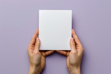 Hands holding a blank square card on a purple background.