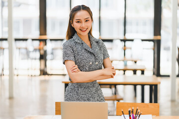 Attractive charming asian woman arms crossed self-confident person worker friendly smile good mood at modern office.