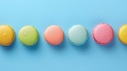 Obraz premium A row of colorful macarons on a blue background