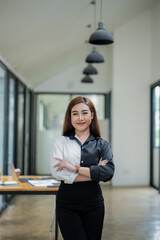 Portrait of a poised Asian businesswoman in a white suit standing confidently in a contemporary...