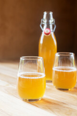 Two glass of homemade Kombucha on the marble table, fermented tea beverages in the sunlight.