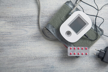 Digital blood pressure machine with a pills on the table. - 789912925