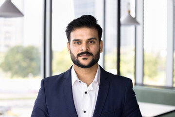 Serious handsome young Indian professional man in formal suit looking at camera. Confident stylish businessman, executive, legal adviser, financial expert head shot portrait