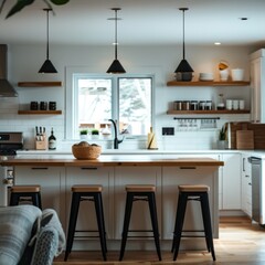 A kitchen with a white counter and black stools. The counter is surrounded by shelves and has a bowl on it. There are several wine glasses and bottles on the counter as well. The kitchen has a modern