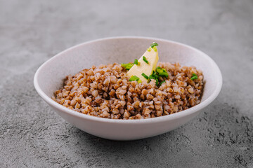 Healthy cooked buckwheat in bowl with butter