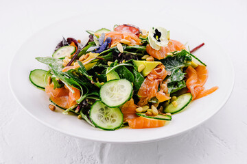 Fresh salmon and spinach salad on white plate